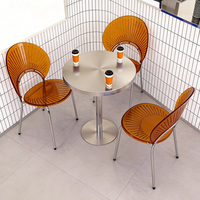 Moderne Kaffeehaus-Tische und -Stühle, ein Runder Edelstahltisch und Transparente Acrylstühle