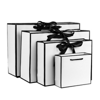 Vente en gros pas cher conception personnalisée cadeau classique vêtement sac en papier à provisions en carton blanc avec poignée en ruban nœud papillon