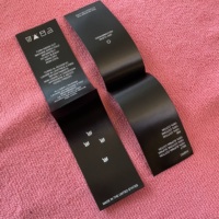 Étiquette de vêtement en satin lavable avec logo imprimé à l'intérieur, étiquette en polyester pliée au centre avec instructions d'entretien pour vêtements de bébé