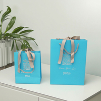 Vente en gros de sacs à provisions de cadeaux en papier bleu ruban de luxe avec impression offset de logo argenté personnalisé pour l'emballage de bougies