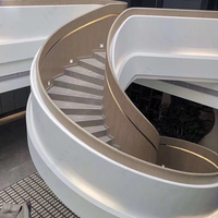 Rampe d'escalier incurvée en acier inoxydable avec éclairage d'accentuation intégré, design écologique et durable pour villa