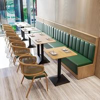 Ensemble de meubles de café moderne, restaurant, tables carrées en bois, chaises en rotin avec coussins verts et banquette en cuir vert
