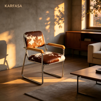 Fauteuil cantilever en cuir de vachette avec structure chromée et accoudoirs en bois, style Mid-Century Modern, motif marron et blanc, pour bureau, salle à manger ou salon.