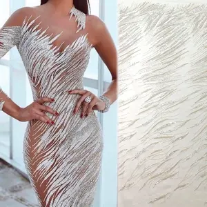 Il design sexy della linea lucida con perline e paillettes argento si abbina al tessuto di pizzo da sposa bianco e oro per abiti