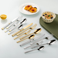 Ensemble de couverts en acier inoxydable argenté poli, comprenant une fourchette à quatre dents, un couteau à lame dentelée à pointe arrondie, une cuillère ovale, et des couverts à dessert, thé, café et salade