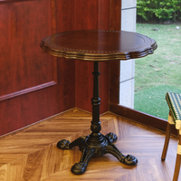 Table de bistrot vintage de style parisien, plateau rond en bois festonné avec base en fonte.