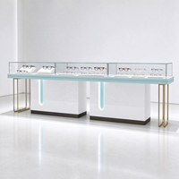 Vitrine de magasin d'optique en verre blanc avec pieds en tube doré, barre lumineuse et protection en verre, certifiée CE ETL pour opticien