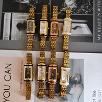 Montre élégante pour femme avec bracelet en acrylique, finition dorée, design cylindrique style cadenas, style médiéval élégant, mouvement à quartz léger