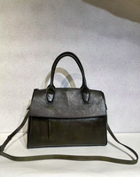 Bolso de cuero de grano completo con solapa, tiradores de cremallera con borlas, herrajes en tono bronce, correa desmontable, estilo vintage hecho a mano