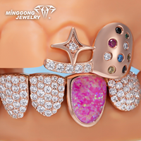 Grillz ouverts personnalisés plaqués or rose et argent, avec détails empreinte digitale, accents de pierres précieuses colorées, pierres latérales en opale rose, et partie inférieure entièrement pavée de pierres.