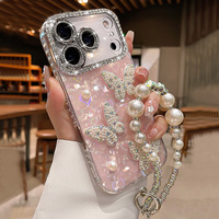 Coque de téléphone de luxe rose en forme de coquille avec papillon 3D et perles, et bracelet chaîne de main en strass scintillant pour iPhone 18 17 Pro Max 16 15 14 13 11