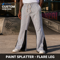 Pantalon de survêtement en coton gris chiné personnalisé avec éclaboussures de peinture noire contrastante, coupe évasée, taille élastique et cordon de serrage pour homme, style streetwear