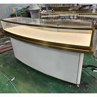 Comptoir de présentation de bijoux en verre incurvé, cadre en acier inoxydable doré brossé, vitrine LED pour boutique de bijoux de luxe