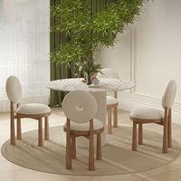 Ensemble de table à manger circulaire en terrazzo de luxe avec chaise à piétement cannelé et dossier torique, design moderne pour hôtel et villa
