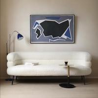 Chaise longue incurvée blanche en bouclette, fauteuil avec rembourrage moelleux, accoudoirs à niveaux, pieds en bois, design moderne pour salon et hôtel