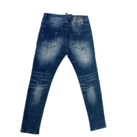 Pantalon slim en denim bleu vintage pour homme, style streetwear automne, avec patch logo au dos, détails déchirés et tissu froissé