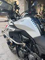Moto de tourisme d'aventure à deux cylindres refroidie par eau de 502 cm3, blanche et noire, avec bagages et barres de protection entièrement en aluminium