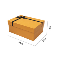 Boîte cadeau en papier orange de luxe avec ruban personnalisable et couvercle sécurisé pour l'emballage de produits haut de gamme