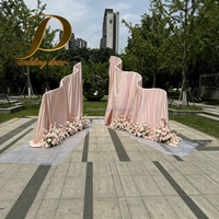 JINDA Rideau en tissu drapé rose poudré à forme ondulée irrégulière avec cadre métallique pour la décoration de scène de mariage en extérieur