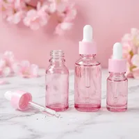 Flacons cosmétiques vides en verre cylindrique rose doré de 30 ml et rose translucide de 50 ml avec impression sérigraphique