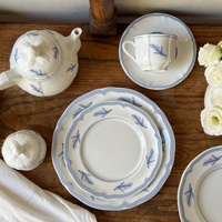 Service de table en céramique bleu vintage français avec motif plume en relief, comprenant un kit de tasses, une théière cannelée et des assiettes creuses, compatible micro-ondes