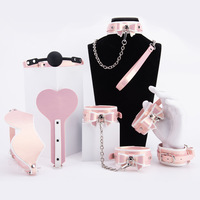 Maßgefertigtes 7-teiliges Rosa PVC-Leder Fesselset Herzförmiger Spanker Gepolsterte Handschellen Augenbinde für Paare Intimes Spiel
