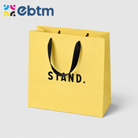 Sacs cadeaux en papier jaune mat personnalisés en gros avec poignées en ruban noir pour sacs cadeaux cosmétiques