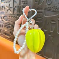 Vente en gros : Breloque de sac banane Kawaii tendance, porte-clés avec nœud et chaîne de perles et fermoir cœur, cadeau adorable pour filles