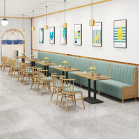 Ensemble de banquettes semi-circulaires en cuir vert et table ronde en bois pour restaurant commercial moderne