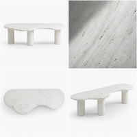 Table basse moderne en travertin beige naturel de forme organique Wabi Sabi, avec 3 pieds cylindriques incurvés irréguliers, finition mate en pierre