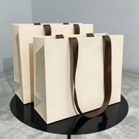 Sac en papier noir gaufré de luxe avec logo personnalisé, en papier texturé, avec poignée en ruban gros-grain pour emballage cadeau