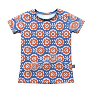 T-shirt pour enfants avec motifs floraux orange et blanc sur fond bleu, créant un design joyeux et ludique, parfait pour tous les jours. - Product Image 1