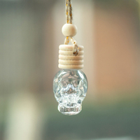 Vente en gros de bouteille en verre de parfum de 8ml en forme de tête de mort diffuseur de parfum de voiture avec corde suspendue bouteille d'aromathérapie en cristal