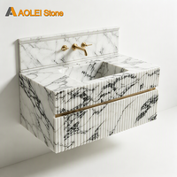 Meuble-lavabo de salle de bain de luxe en marbre blanc et noir cannelé. Lavabo mural en pierre moderne pour hôtel haut de gamme.