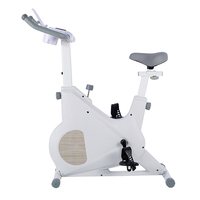 Vélo d'exercice à domicile blanc avec transmission par courroie magnétique, support pour tablette et porte-gobelet pour un entraînement cardio confortable en intérieur