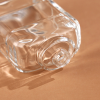 Bouteille d'huile essentielle en verre bouclé de forme de luxe vide au design unique Bouteille d'eau parfumée avec couvercle noir