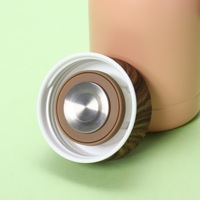 Bouteille isotherme compacte et portable en acier inoxydable avec couvercle imitation bois, idéale pour l'extérieur