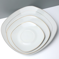 Vente en gros d'assiettes blanches en vrac de haute qualité, assiettes rondes en porcelaine en céramique, assiettes irrégulières de restaurant avec bordure dorée