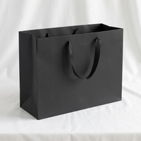 Sac cadeau en papier noir mat haut de gamme avec poignée en ruban gros-grain noir, logo de marque personnalisé, revêtement UV, sac d'expédition pour institut de beauté et spa
