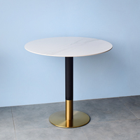 Table ronde en pierre frittée avec structure en métal doré et ensemble de fauteuils en cuir pour café, boulangerie, salon de thé, mobilier commercial