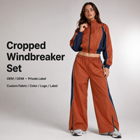 Ensemble coupe-vent en gros avec pantalon large contrastant orange et bleu marine à fermeture éclair, faible MOQ, ensemble coupe-vent court