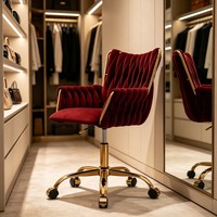 Fauteuil de détente en velours rouge, dossier haut capitonné, hauteur réglable, base pivotante en métal doré, roulettes