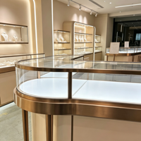 Comptoir de présentation de bijoux en verre incurvé, cadre en métal rose doré, vitrine aux coins arrondis avec éclairage LED chaud intégré, logo personnalisé