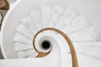 Escalier en spirale moderne en béton sur mesure, à double poutre en acier forgé à la main, avec garde-corps en verre, pour usage hôtelier