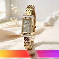 Montre élégante pour femme avec bracelet en acrylique, finition dorée, design cylindrique style cadenas, style médiéval élégant, mouvement à quartz léger