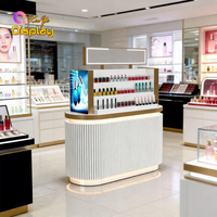 Îlot de présentation de parfums de luxe moderne avec éclairage LED, en MDF et acier inoxydable, base cannelée noire, taille et couleur personnalisables pour le haut de gamme