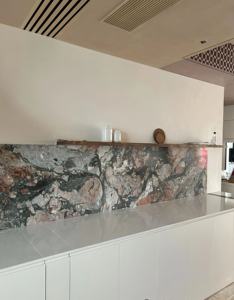 Cuisine moderne avec crédence en pierre naturelle et îlot, armoires blanches, étagères ouvertes - Product Image 5