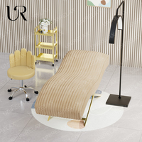 Union Win Nouveau design Table de massage pour salon de beauté Lit à cils incurvé en cuir rose avec base en métal doré Lit de massage pour cils de luxe