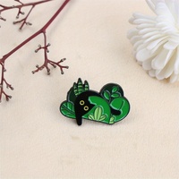 Épingle en émail de créature de forêt enchanteresse-Figure noire parmi les feuilles vertes. Un accessoire fantaisiste pour les amoureux de la nature