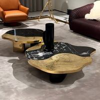 Ensemble de tables basses de luxe moderne en marbre noir avec bordure dorée, structure métallique, forme irrégulière, combinaison de meubles pour salon